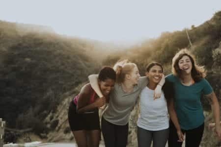 group of women on hike holding each other arm and arm and over the shoulders while laughing and walking - Prevent & Avoid Chafing - Body Glide