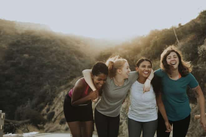 group of women on hike holding each other arm and arm and over the shoulders while laughing and walking - Prevent & Avoid Chafing - Body Glide