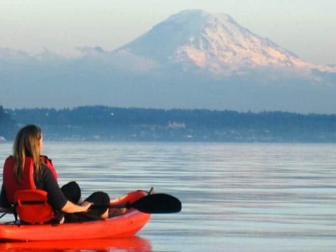 woman in kayak gazing toward mountain