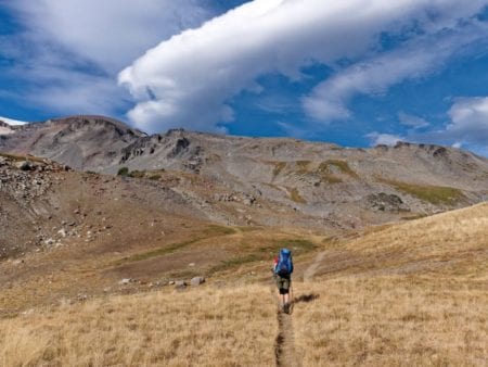 Person hiking through a mountainous landscape.